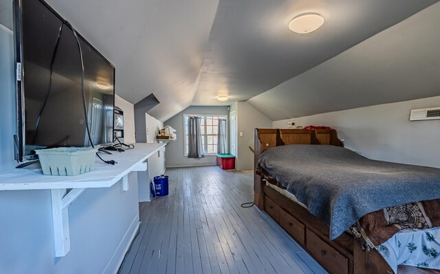 bedroom featuring hardwood / wood-style floors and vaulted ceiling