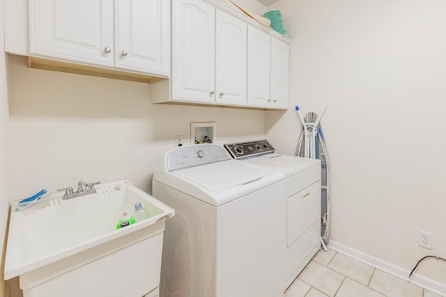 2036 Hickory Valley Rd, Chattanooga, TN 37421 - washroom featuring washing machine and dryer, cabinet space, light tile patterned floors, and baseboards