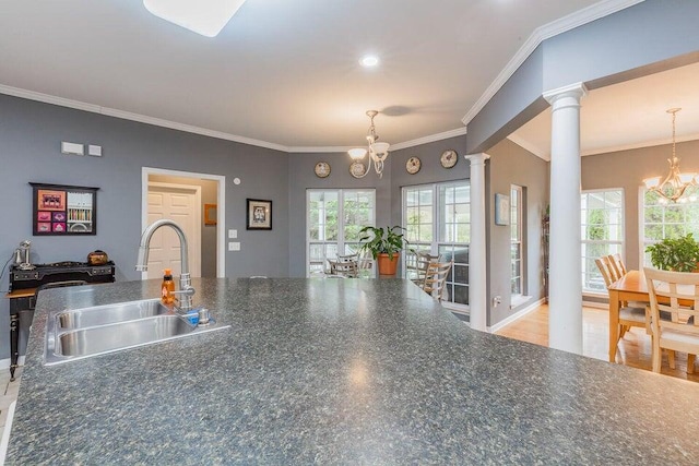 2036 Hickory Valley Rd, Chattanooga, TN 37421 - kitchen featuring a chandelier, a sink, ornate columns, dark countertops, and crown molding