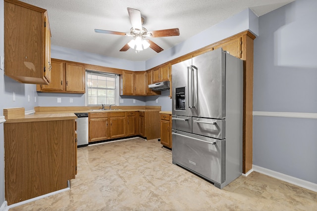 kitchen with ceiling fan, sink, a textured ceiling, and appliances with stainless steel finishes