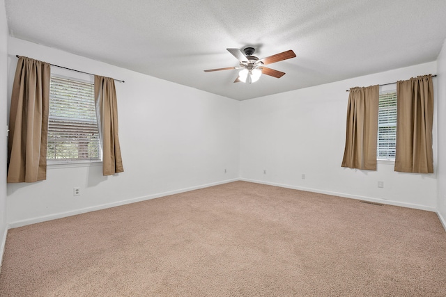 carpeted spare room with ceiling fan and a textured ceiling