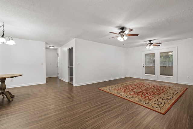 interior space with ceiling fan with notable chandelier, a textured ceiling, and dark hardwood / wood-style flooring