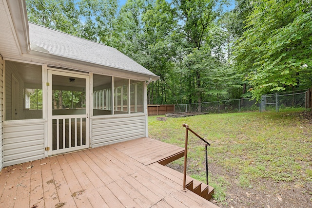 wooden terrace featuring a yard and a sunroom