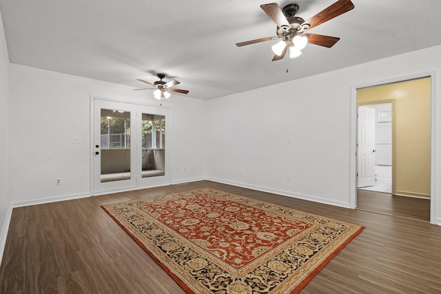 spare room featuring ceiling fan, dark wood-type flooring, and a textured ceiling