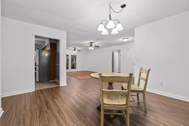 dining area featuring a textured ceiling, ceiling fan with notable chandelier, and dark hardwood / wood-style floors