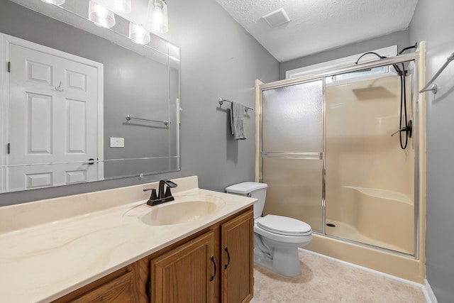 bathroom featuring vanity, toilet, an enclosed shower, and a textured ceiling