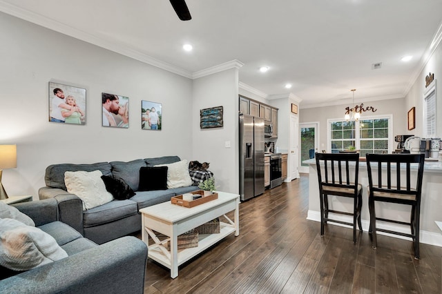 living area featuring dark wood-type flooring, visible vents, ornamental molding, recessed lighting, and an inviting chandelier