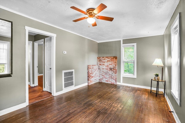 unfurnished living room with plenty of natural light, dark hardwood / wood-style flooring, and a textured ceiling