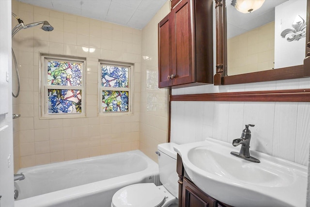 full bathroom with vanity, toilet, tile walls, and tub / shower combination