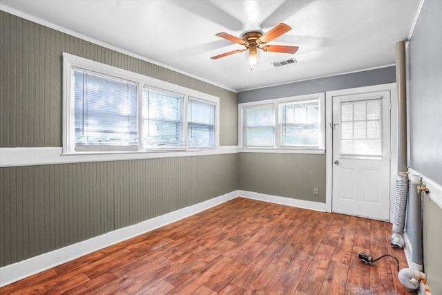 unfurnished room featuring wood-type flooring, ceiling fan, and ornamental molding