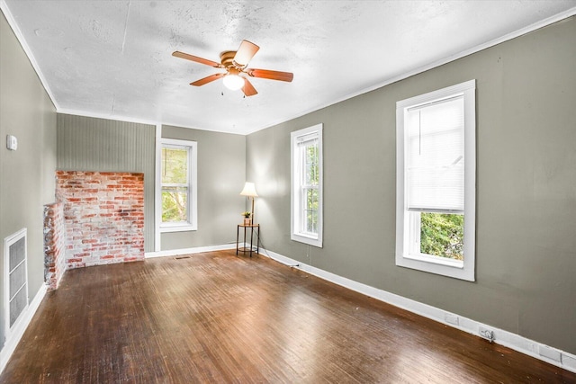 unfurnished living room featuring ceiling fan, wood-type flooring, a textured ceiling, and ornamental molding