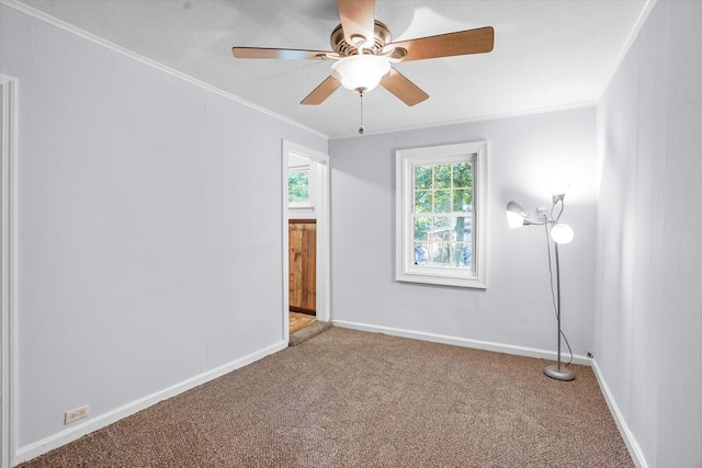 carpeted spare room featuring ceiling fan and ornamental molding