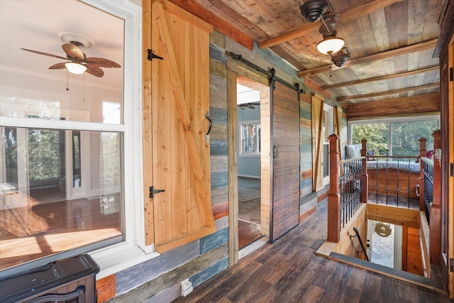 sunroom / solarium with beamed ceiling, ceiling fan, a barn door, and wooden ceiling