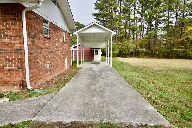 view of side of home featuring a lawn and a carport