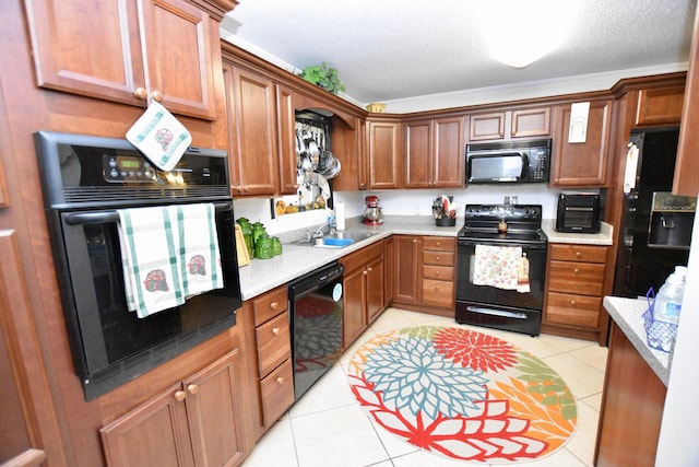 kitchen featuring sink, light tile patterned floors, a textured ceiling, and black appliances