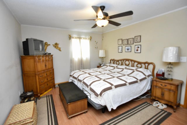 bedroom featuring ceiling fan, light hardwood / wood-style floors, and ornamental molding