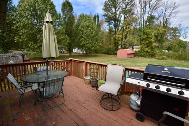 wooden terrace with a yard, grilling area, and a storage shed