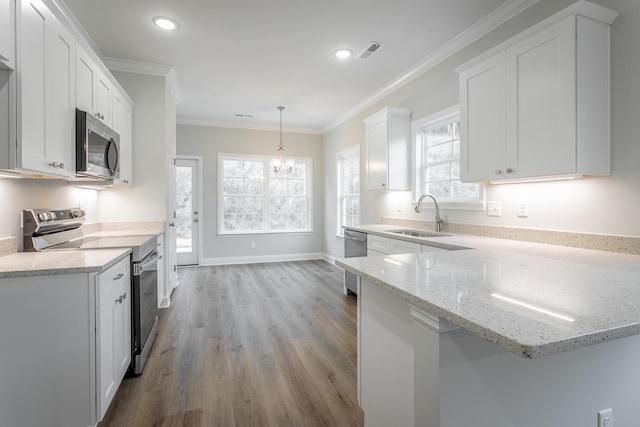 kitchen with light stone counters, stainless steel appliances, crown molding, sink, and white cabinets