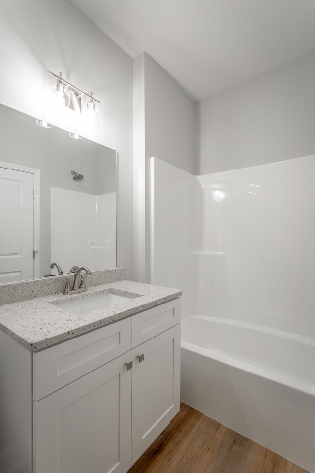 bathroom featuring bathing tub / shower combination, vanity, and hardwood / wood-style flooring