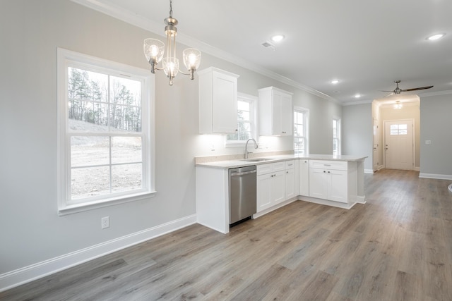 kitchen with white cabinets, sink, hanging light fixtures, stainless steel dishwasher, and kitchen peninsula