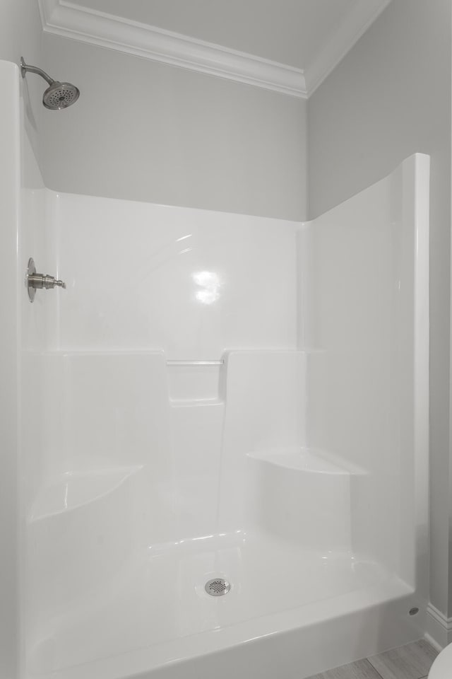 bathroom with a shower and crown molding