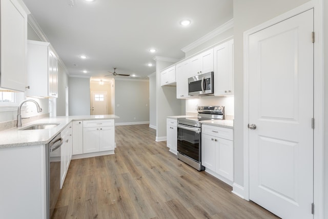 kitchen featuring kitchen peninsula, appliances with stainless steel finishes, ceiling fan, sink, and white cabinets