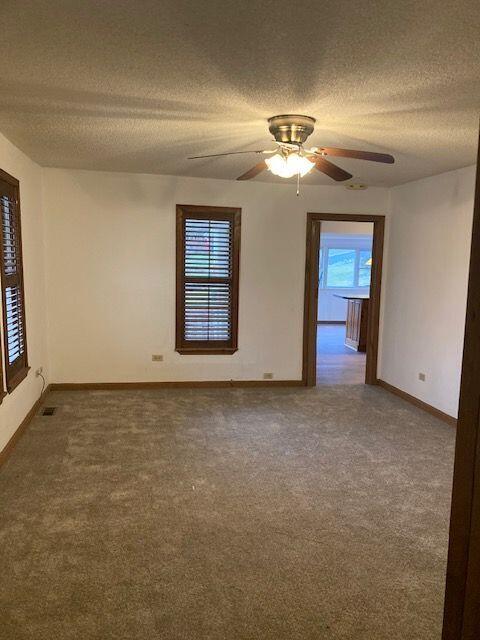 spare room featuring ceiling fan, carpet floors, and a textured ceiling