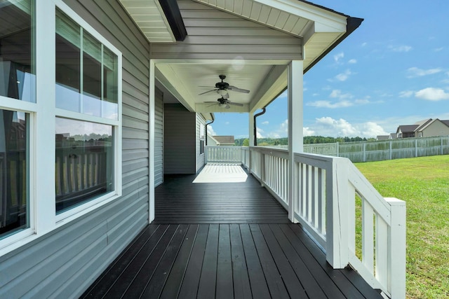 wooden terrace featuring ceiling fan and a yard