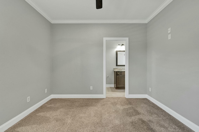 unfurnished bedroom with ceiling fan, light colored carpet, ornamental molding, and ensuite bathroom