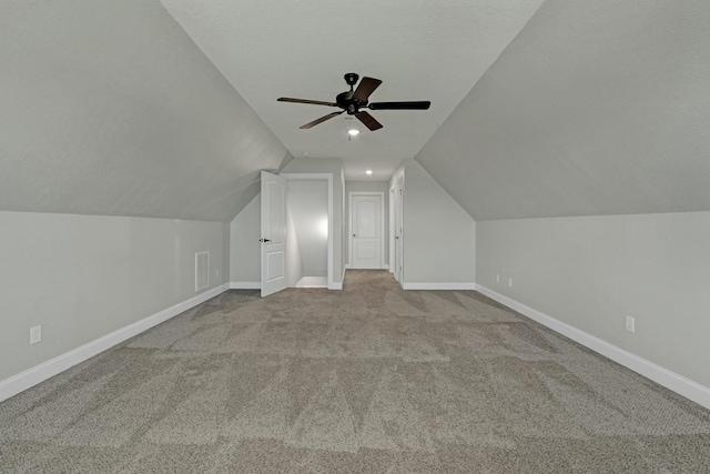 additional living space featuring lofted ceiling, light colored carpet, and ceiling fan