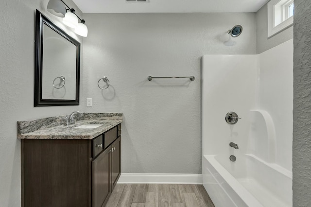 bathroom with vanity, hardwood / wood-style floors, and  shower combination