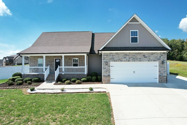 view of front facade featuring a garage, a front yard, and a porch