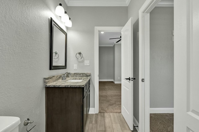 bathroom featuring vanity, crown molding, wood-type flooring, and toilet