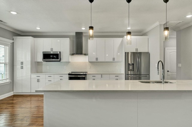 kitchen featuring stainless steel appliances, white cabinetry, sink, and wall chimney exhaust hood