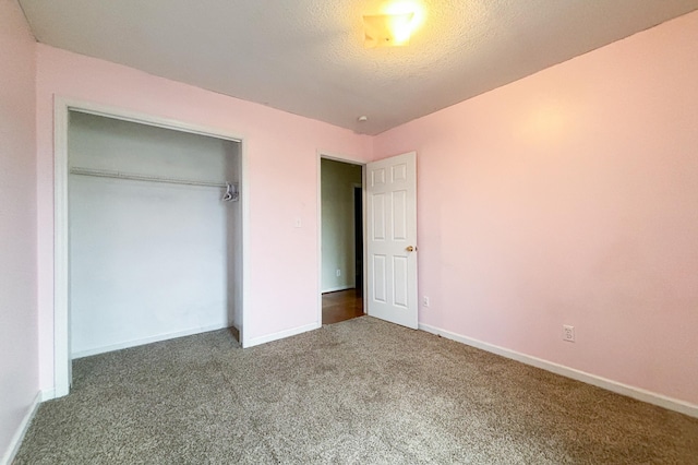 unfurnished bedroom featuring a closet, baseboards, carpet floors, and a textured ceiling