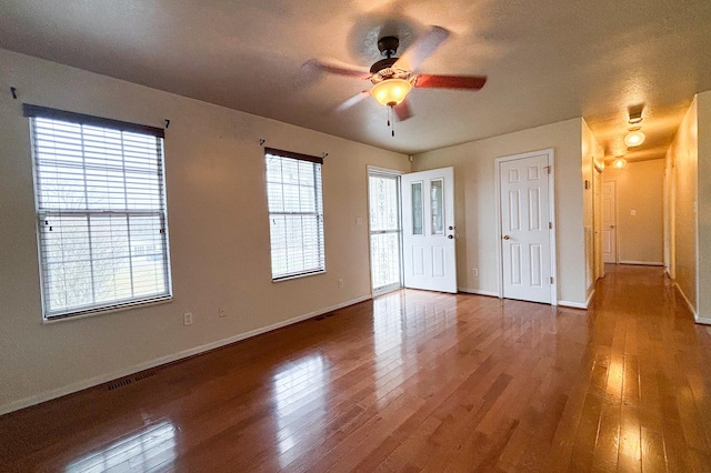 spare room with hardwood / wood-style floors, baseboards, and ceiling fan