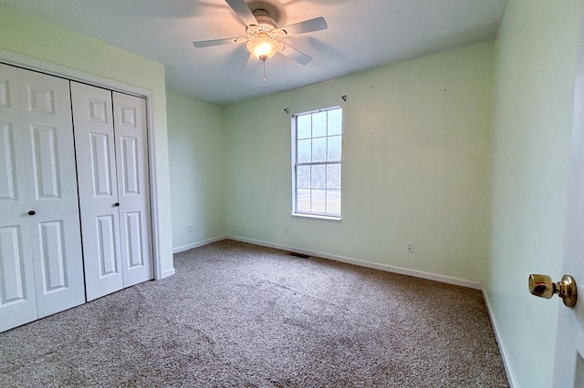 unfurnished bedroom featuring a closet, baseboards, a ceiling fan, and carpet flooring