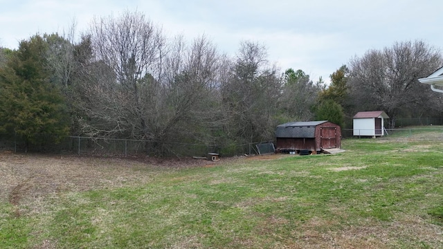 view of yard featuring an outbuilding, a fenced backyard, and a shed