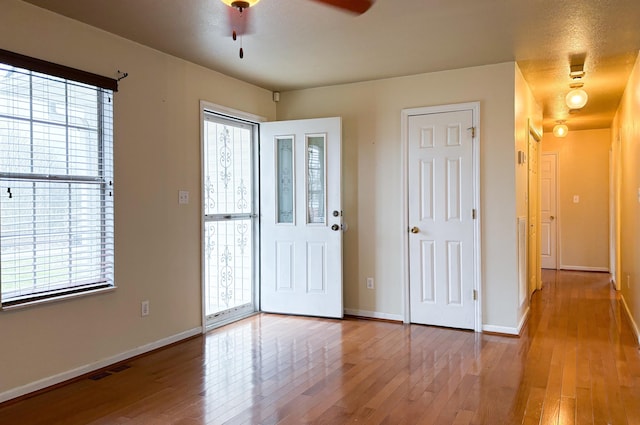 entryway with a wealth of natural light, visible vents, baseboards, and hardwood / wood-style flooring