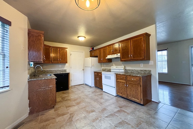 kitchen featuring visible vents, baseboards, under cabinet range hood, white appliances, and a sink