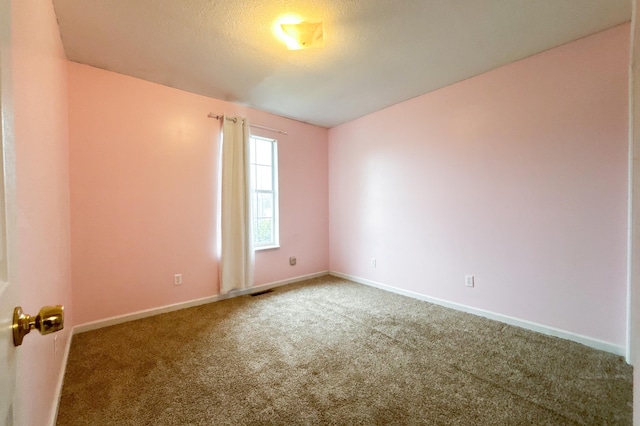 empty room featuring visible vents, baseboards, carpet, and a textured ceiling