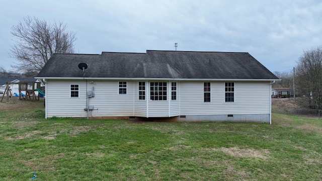 back of house featuring a playground, a yard, roof with shingles, and crawl space