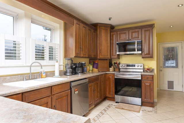 kitchen featuring sink, light tile patterned floors, and stainless steel appliances