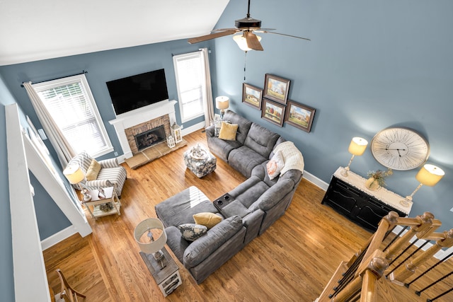 living room featuring hardwood / wood-style floors, ceiling fan, and vaulted ceiling