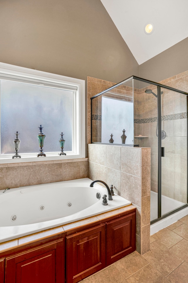 bathroom with tile patterned flooring, separate shower and tub, and vaulted ceiling