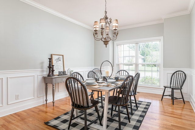 dining room featuring a chandelier, light hardwood / wood-style floors, and ornamental molding