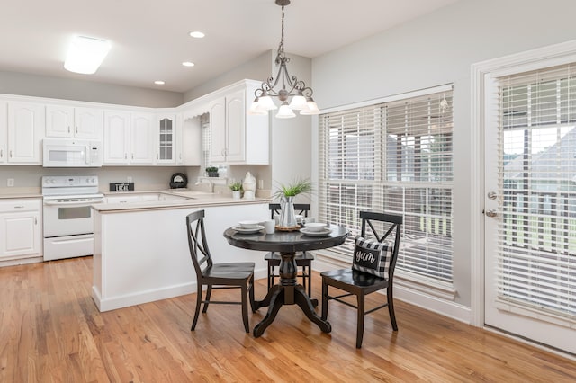 kitchen featuring white cabinets, pendant lighting, white appliances, and light wood-type flooring