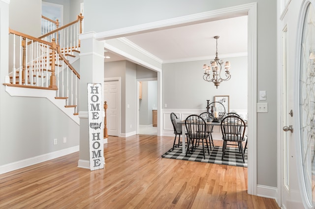 dining area featuring a chandelier, wood-type flooring, and ornamental molding