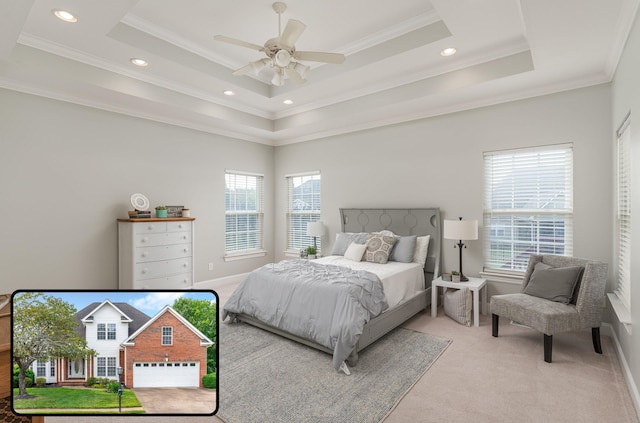 bedroom with a raised ceiling, multiple windows, ornamental molding, and ceiling fan