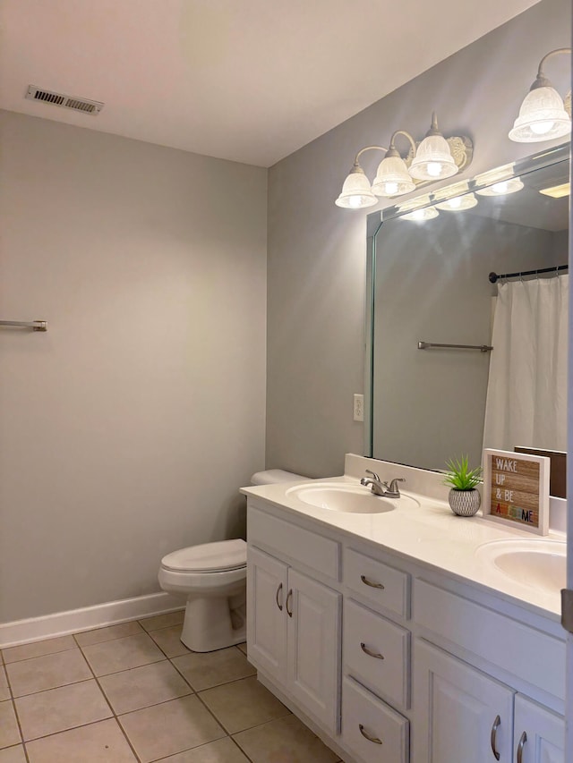 bathroom with tile patterned flooring, vanity, toilet, and curtained shower